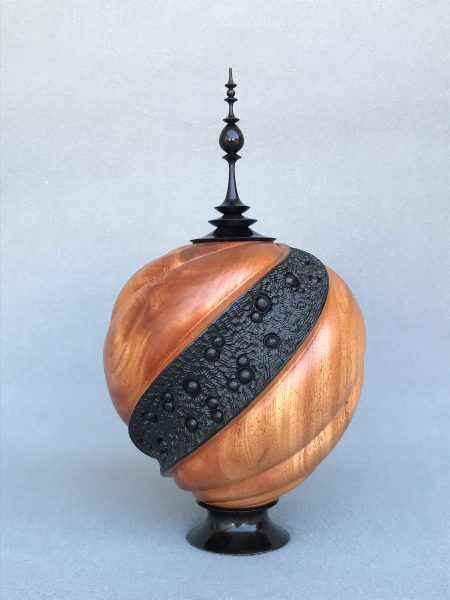 Photo of a spiral-carved hollow vessel with a finial.